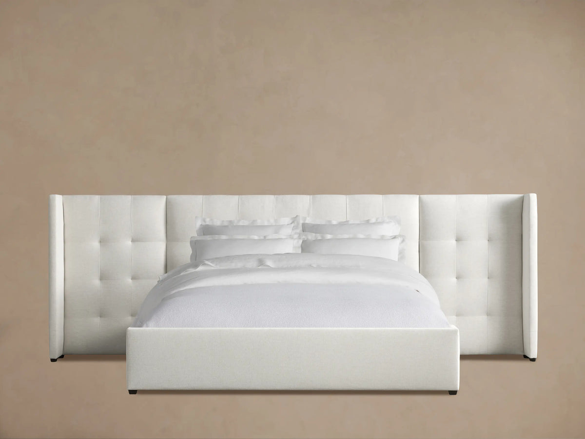 Close-up of Wyller Box-Tufted Extended Headboard. Light cream textured fabric, detailed box tufting, and extended side panel.