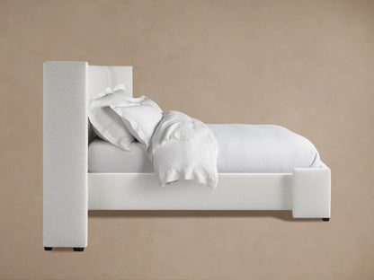 Wyller Extended Headboard, close-up of an upholstered corner in light textured fabric against a beige wall.