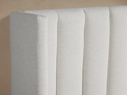 White Wyller Channel-Stitched Bed featuring a vertically-stitched headboard, low footboard, and white bedding.