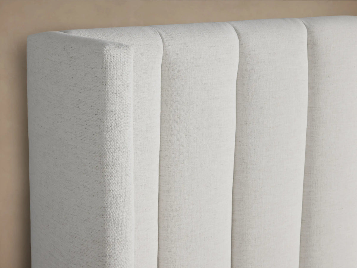 Wyller Channel-Stitched Bed in white, with a tall wingback headboard, vertical stitching, low footboard, and white bedding.