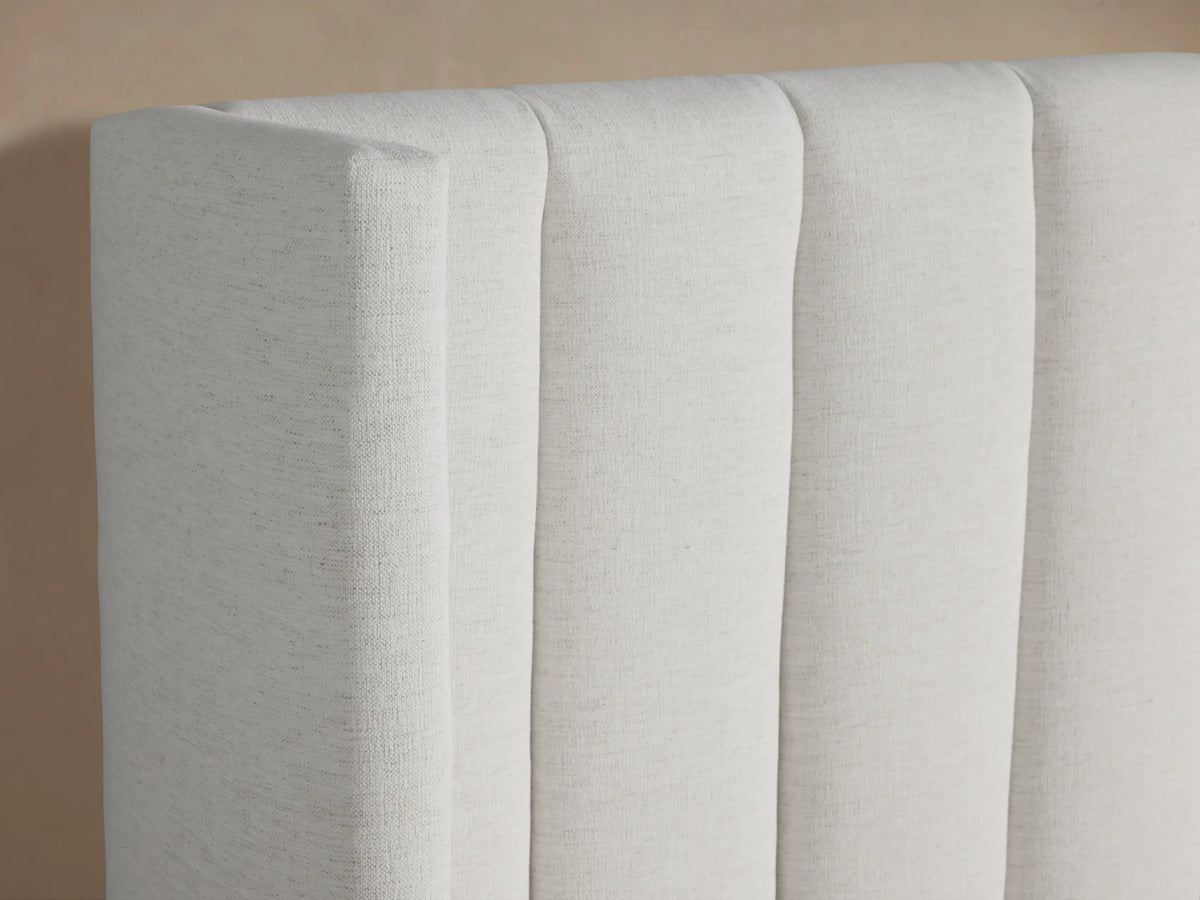 Front view of white Wyller Channel-Stitched Bed with Low Footboard. Tall headboard features vertical channel stitching, white bedding.