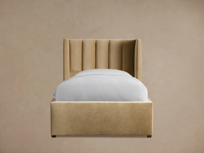 Wyller Channel-Stitched Twin Bed in camel velvet, with a tall, winged channel-stitched headboard & white bedding, on wood floor.