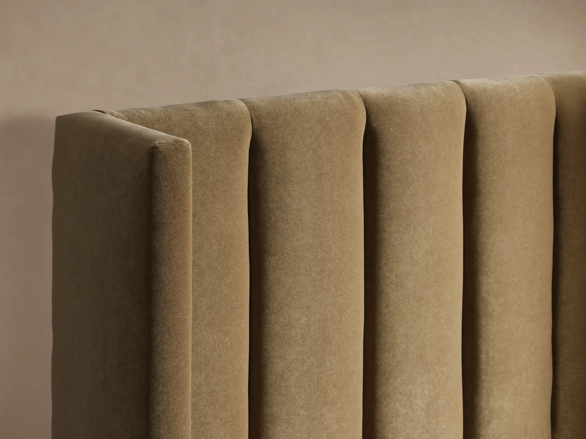 Wyller Channel-Stitched Twin Bed, upholstered in plush beige fabric with a vertically channel-stitched headboard and white bedding.