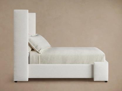 Close-up, angled view of the Wyller Channel-Stitched Twin Bed's light beige upholstered headboard with vertical channel stitching.