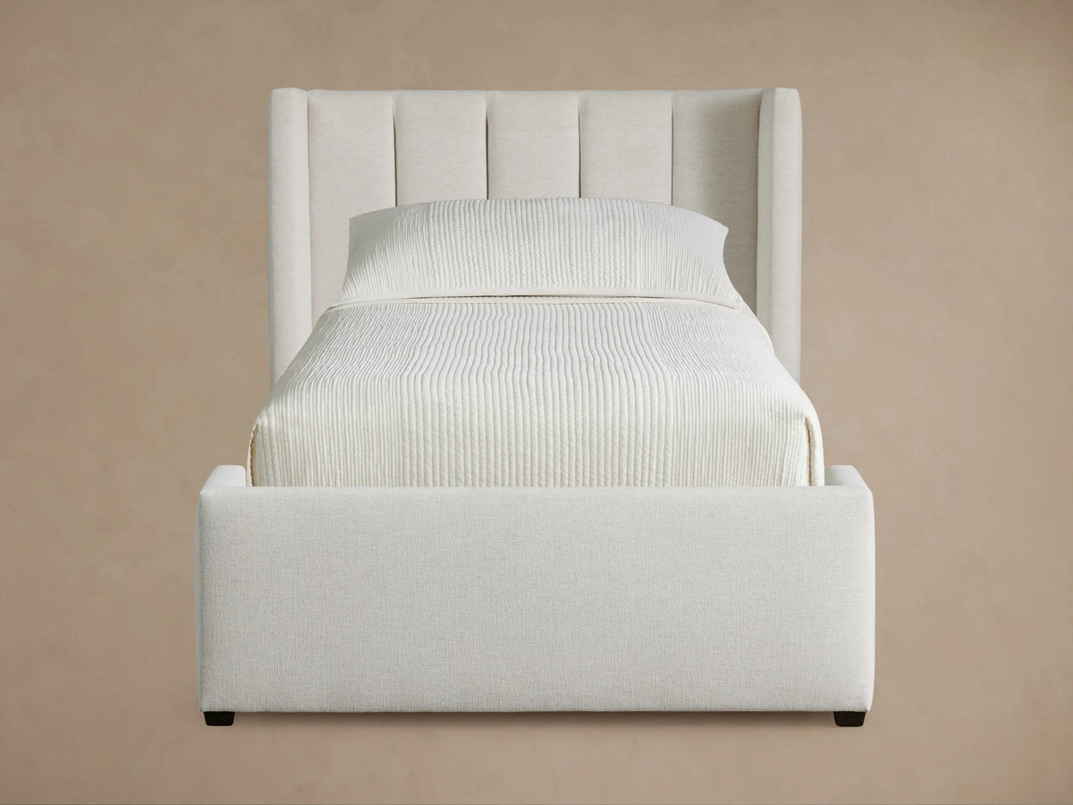 Wyller Channel-Stitched Twin Bed, light beige upholstered bed with vertical channel stitching on headboard, on wood floor.