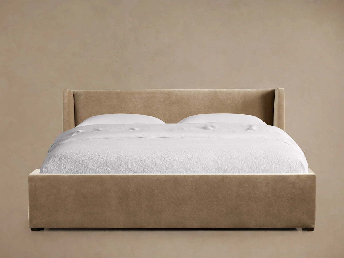 Front view of a tan Wyller Bed with Low Headboard, featuring a low, flared headboard and white bedding.