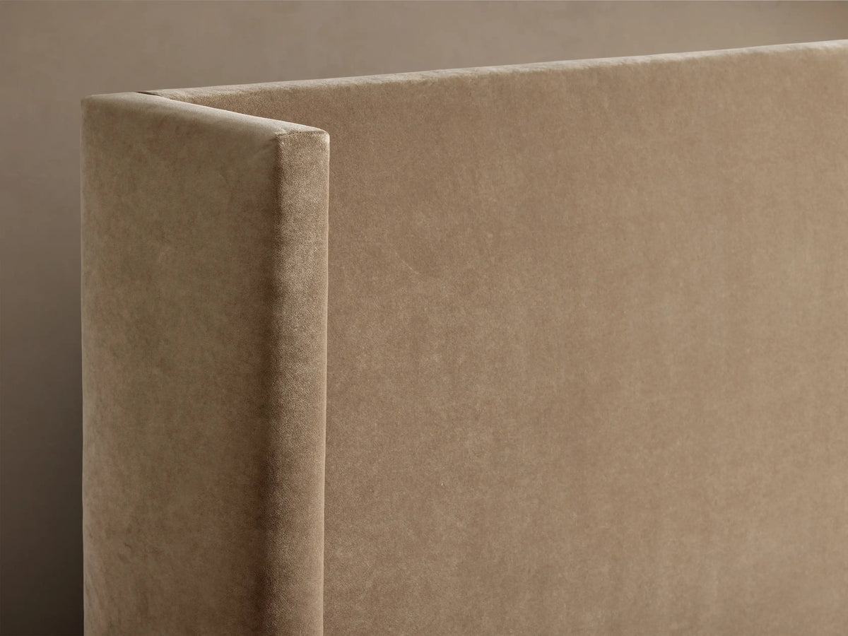 Close-up of the light brown upholstered Wyller Bed with Low Headboard, showing the textured fabric and structured corner.