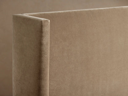 Close-up of Wyller Bed's upholstered headboard corner, showing plush, beige-taupe velvet fabric and soft texture.