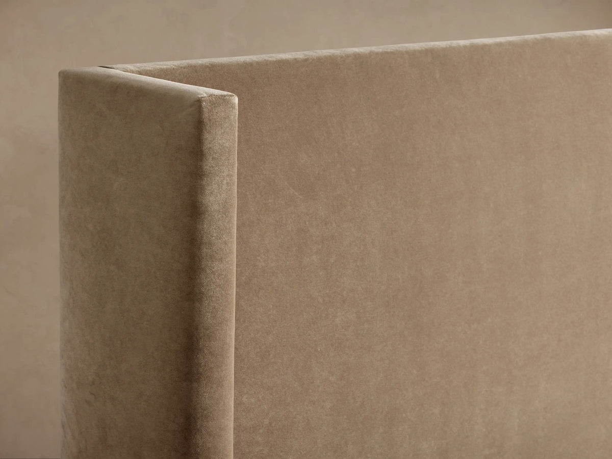 Wyller Bed, beige upholstered with a tall, slightly winged headboard. White pillows & duvet, front view on a neutral background.