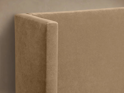 Wyller Twin Bed with upholstered beige frame, high wingback headboard, and white bedding, centered against a beige wall.
