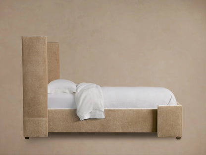 Close-up of Wyller Twin Bed's upholstered headboard corner in soft light tan fabric, showing fine texture and seam stitching.