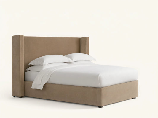 Wyller Twin Bed with light brown upholstered wingback headboard & frame, white mattress & bedding, on a dark wood floor.
