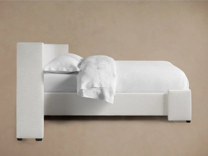 Close-up of Wyller extended headboard in light textured fabric with vertical channel stitching and a wrapped side panel.