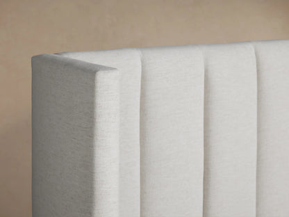Wyller Channel-Stitched Extended Headboard Bed: off-white upholstered frame & vertical channel-stitched headboard, white bedding.