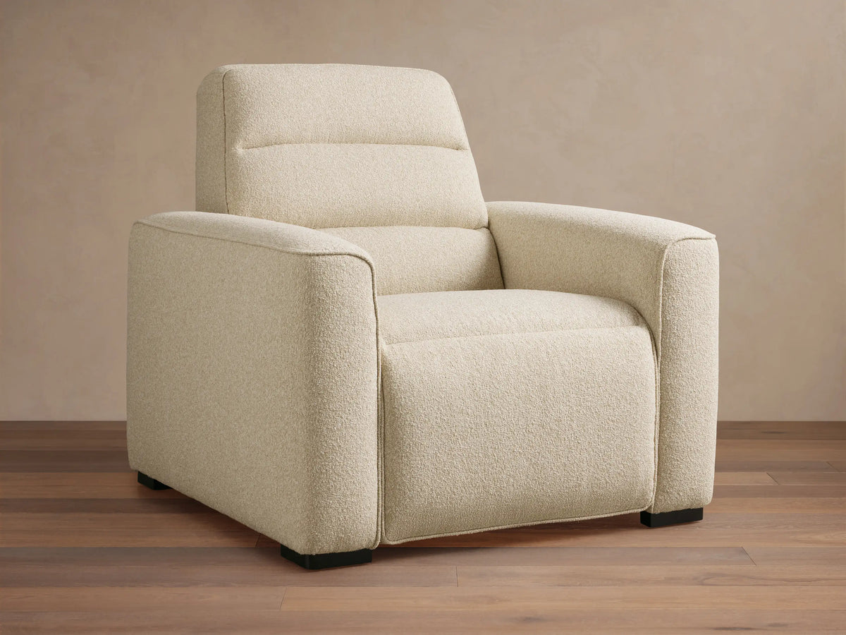 Front view of a Cream Borough Motion Recliner with textured bouclv© fabric, plush arms, and a quilted backrest.