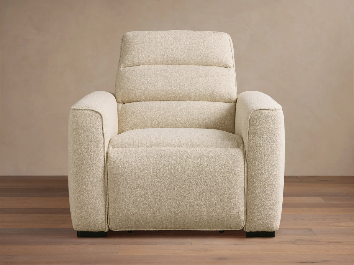 Front view of a Cream Borough Motion Recliner with textured bouclv© fabric, plush arms, and a quilted backrest.