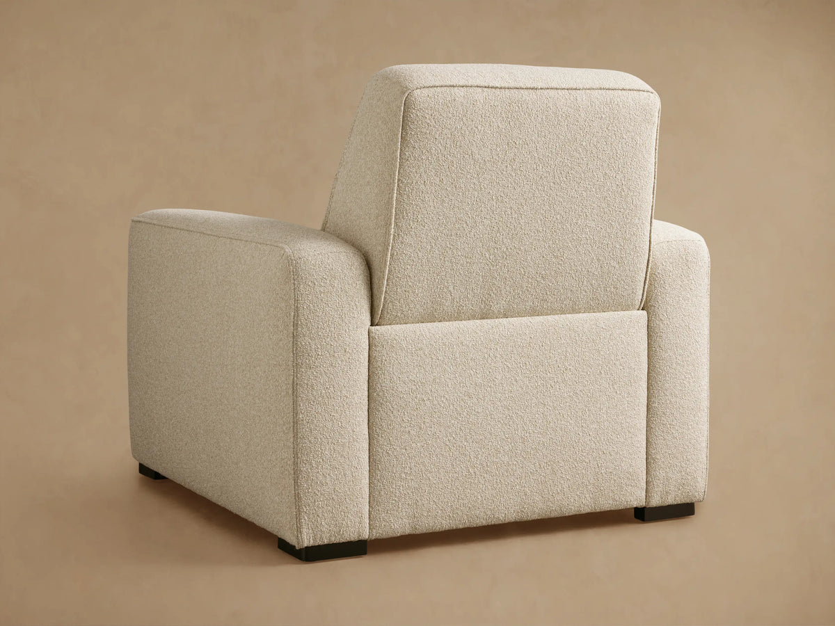 Close-up of the Cream textured fabric on the Borough Motion Recliner, showing the armrest, seat, and channel-tufted back.
