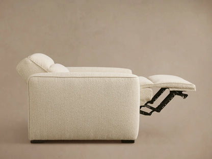 Front-side view of a cream Borough Motion Recliner with wide arms, padded back, and extended footrest.