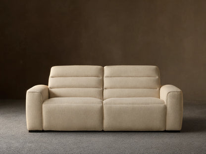 Front view of the cream Borough Two-Piece Motion Sofa, a two-seater with horizontally stitched back cushions and wide armrests.