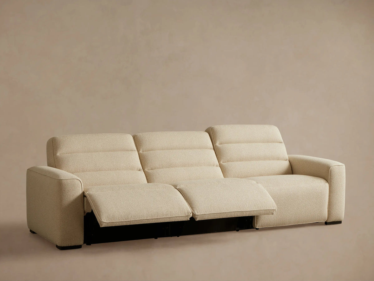 Rear view of the cream Borough Three-Piece Motion Sofa, showing its three textured fabric sections and dark feet.
