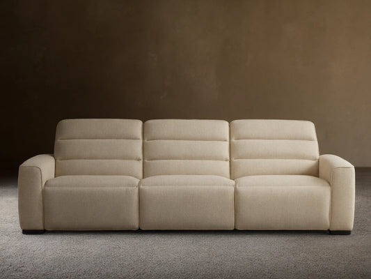 Front view of the light cream Borough Three-Piece Motion Sofa with horizontal stitched backrests and block arms.