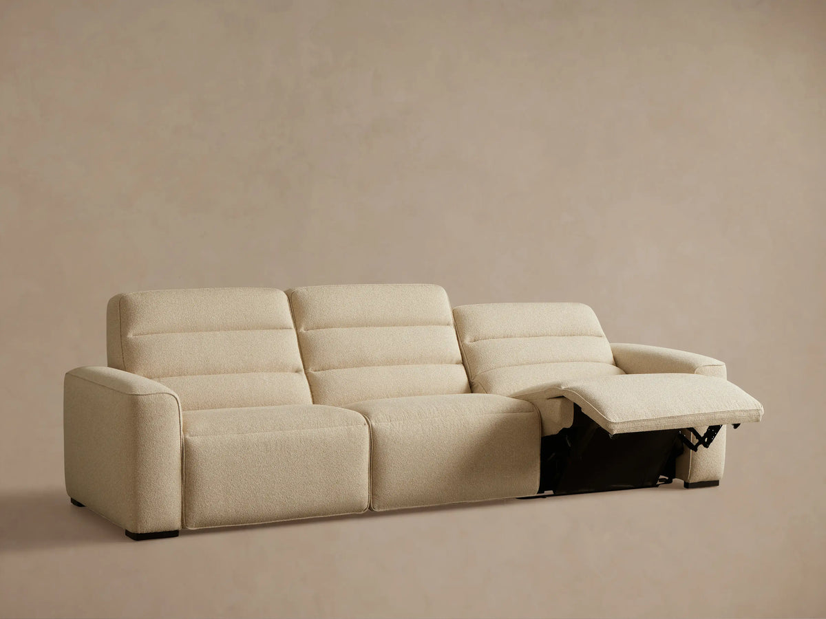 Front view of light beige Borough Three-Piece Motion Sofa‚Ñ¢ with both end seats reclined and footrests extended.