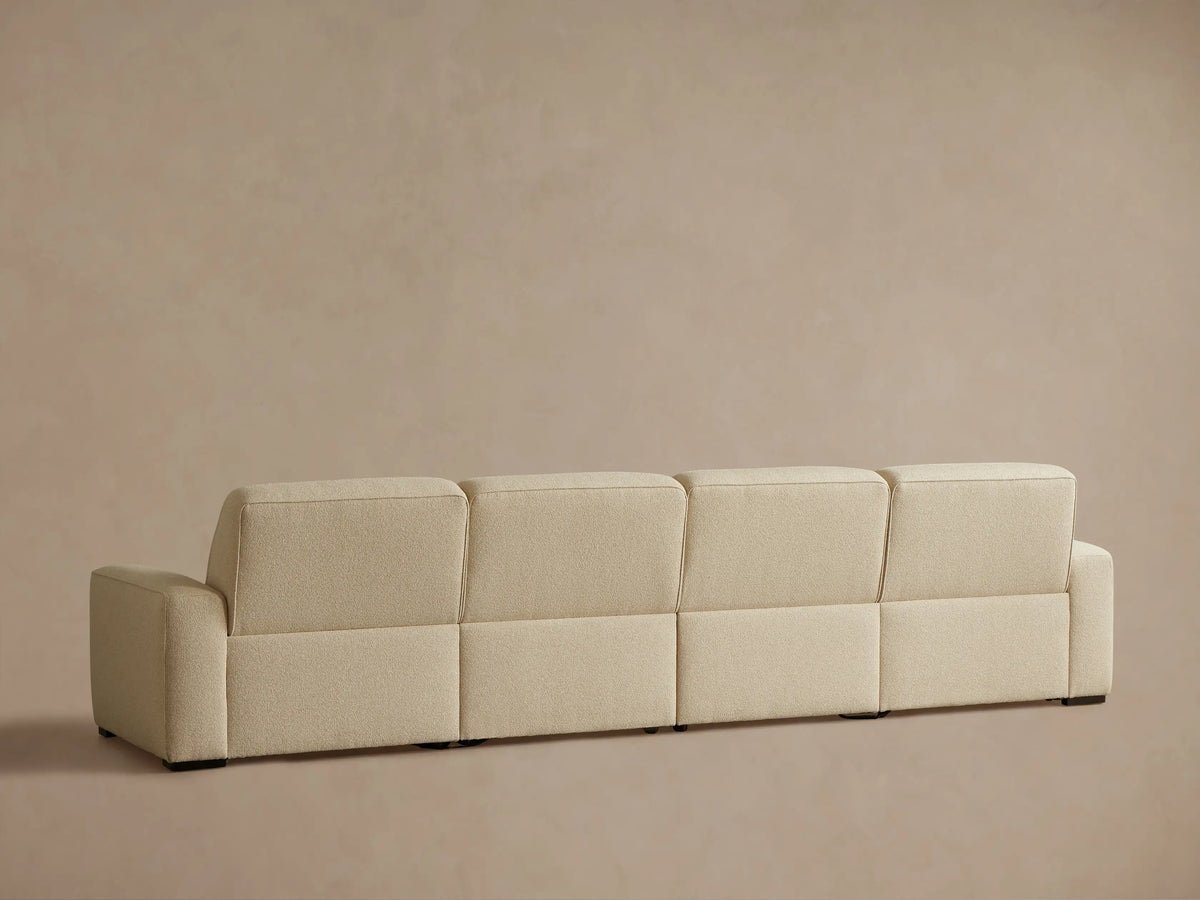 Close-up of the beige textured fabric upholstery on the Borough Four-Piece Motion Sectional, showing two dark motion control buttons.