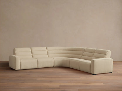 Front view of a cream Borough Five-Piece Motion Corner Sectional with horizontal ribbed recliners and a curved tufted corner.