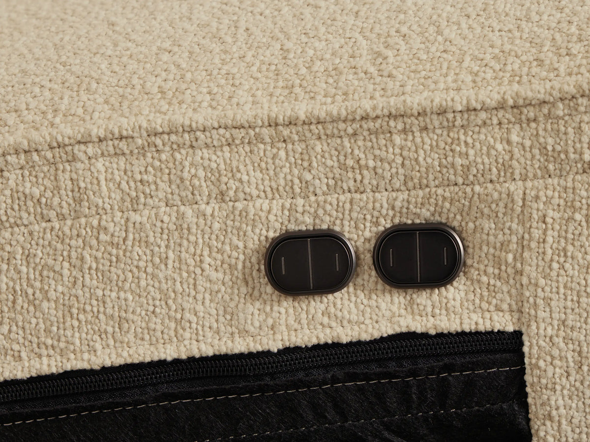 Close-up of the Cream textured fabric Borough Five-Piece Motion Corner Sectional, with a recliner's footrest extended.