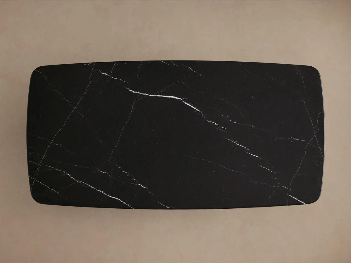 Front view of the black Saint Germain Stone Coffee Table with Dauphine Base. Rectangular top with light veining, two curved black wood bases.