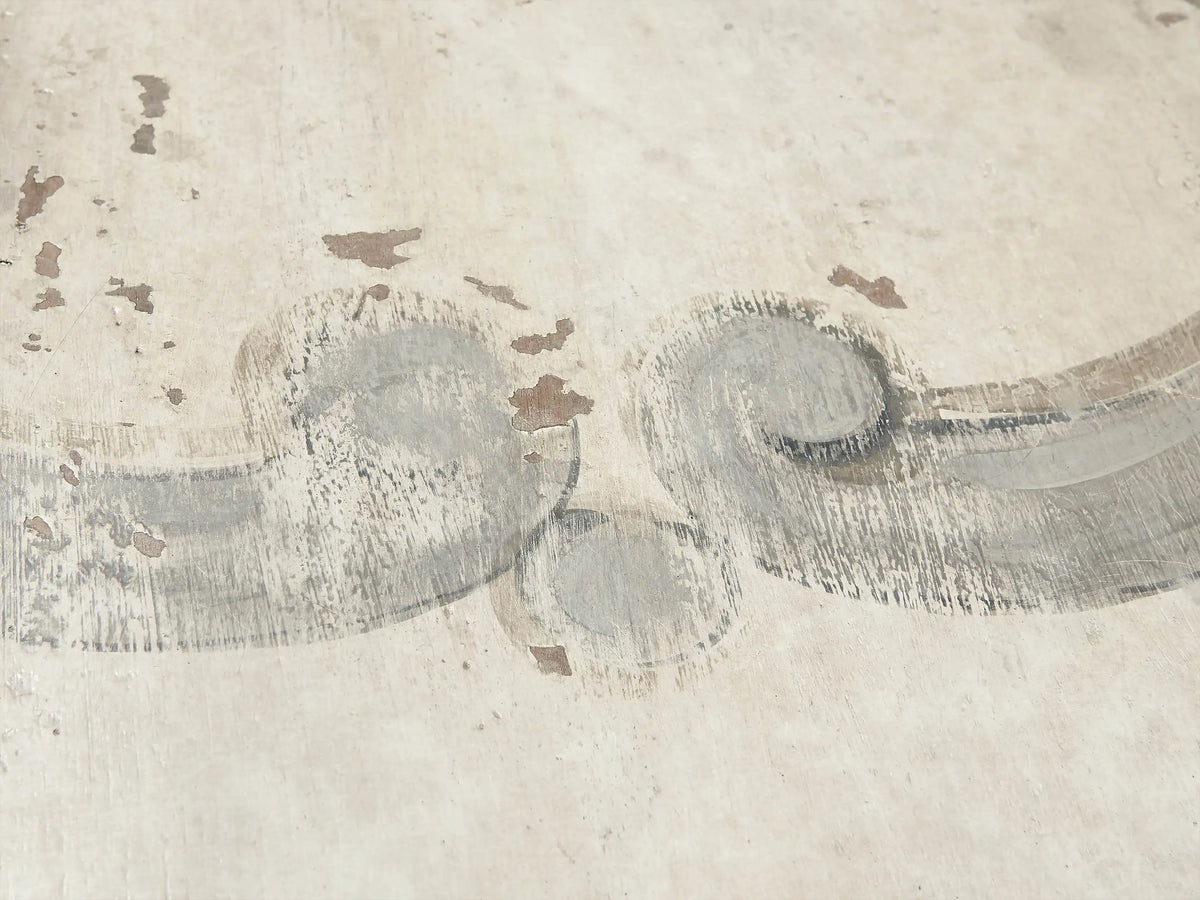 Close-up of a distressed, hand-painted Antique Grey floral design on the Antique White top of the Biancca dining table.