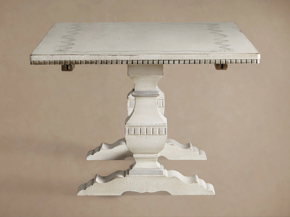 Close-up of Cerea Ribbon Bell'Arte Dining Table corner, showing light gray top with hand-painted dark gray ribbon border, distressed edges, and white carved leg.