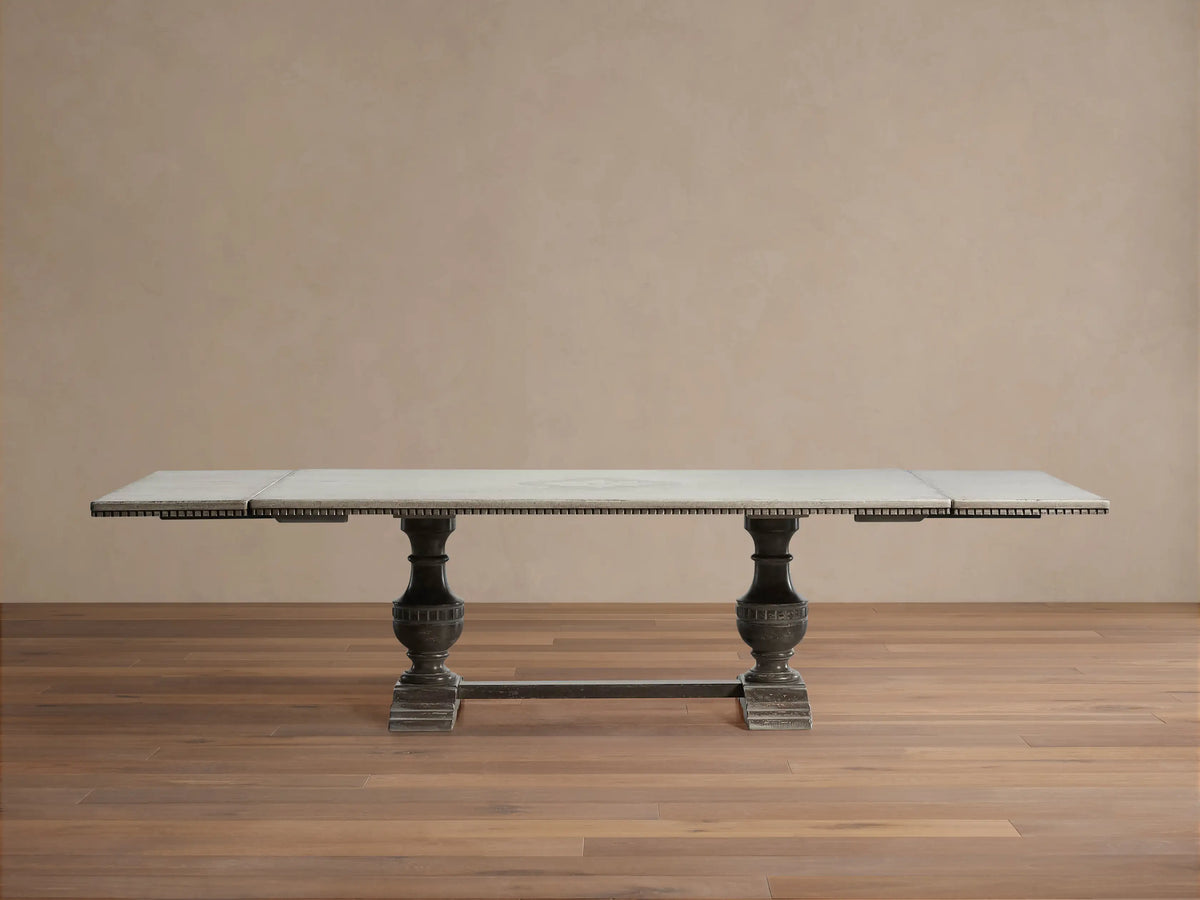Florence Bell‚ÄôArte Dining Table. Rectangular Ivory Grey top with carved dark edge, supported by two ornate Dark Rust pedestal bases.