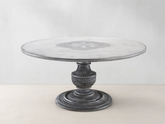 Florence Bell‚ÄôArte Round Dining Table. Distressed ivory grey top with central floral design, dark rust carved pedestal base.