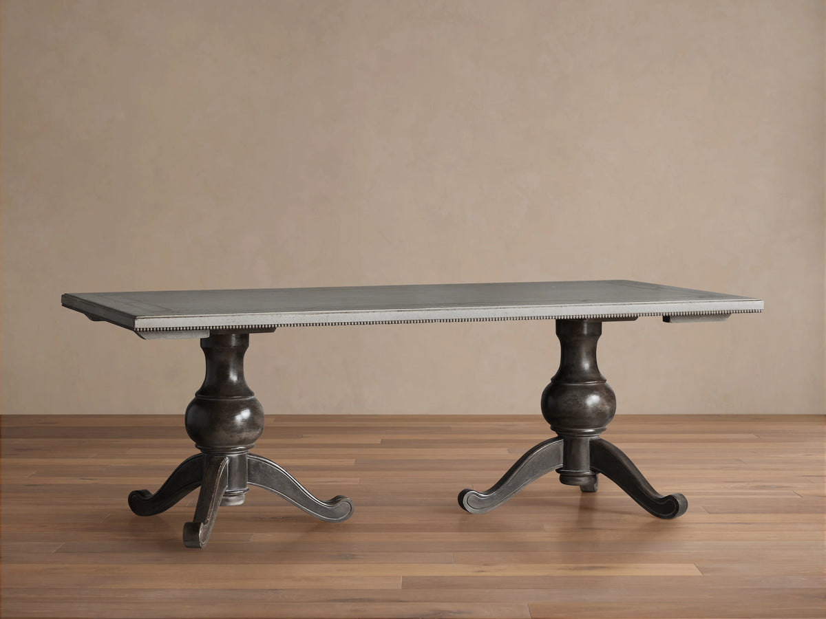 Girardi Geo Link Bell'Arte Dining Table with antique white top, geometric grey border, and two ornate dark wooden pedestals.