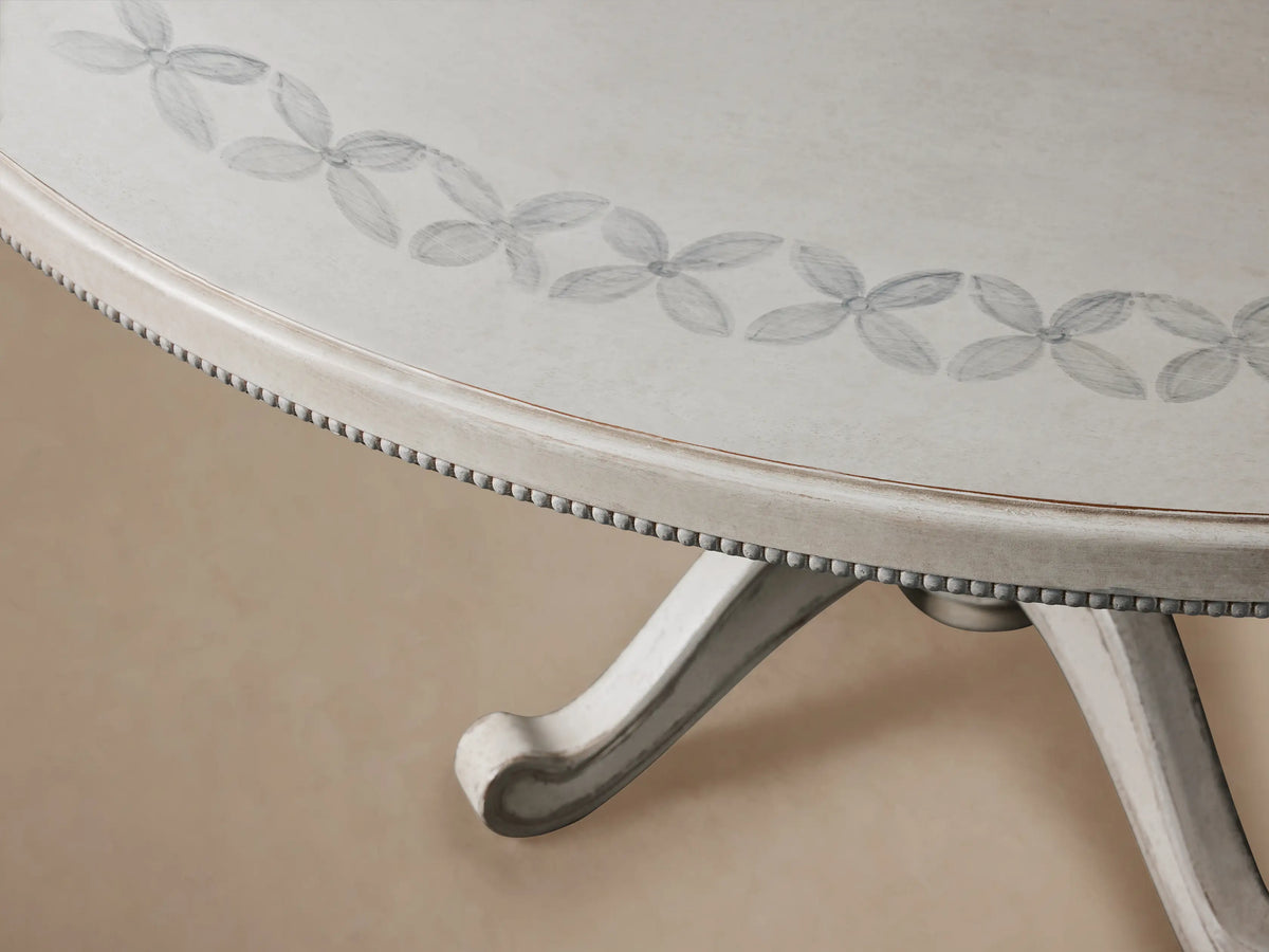 Round Girardi Margherita Bell'Arte dining table in distressed antique white with hand-painted edge pattern and pedestal base.