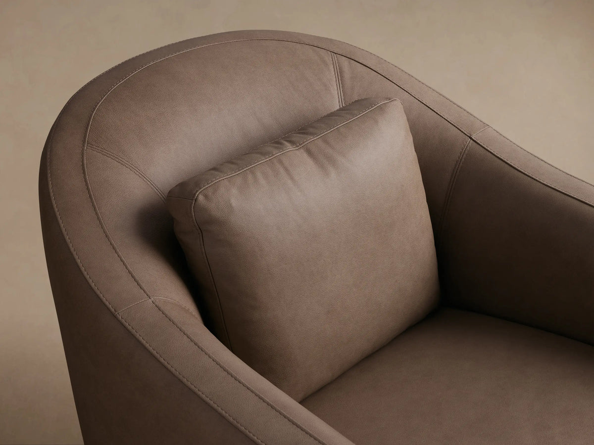 Front view of a taupe Bianca Leather Swivel Chair with rounded arms, a separate seat cushion, and a small back pillow.