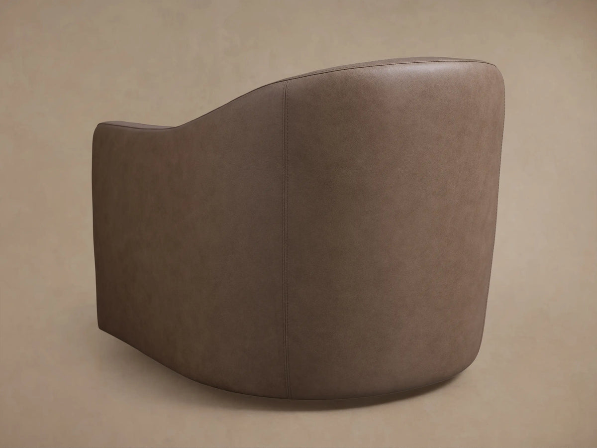Close-up of the taupe brown Bianca Leather Swivel Chair, showing its curved backrest with fine stitching and a matching square cushion.
