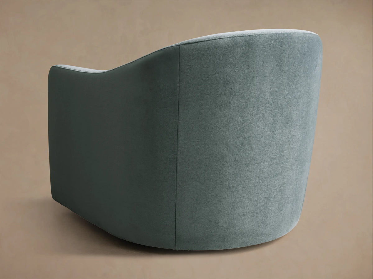 Close-up of the teal Bianca Swivel Chair, showing a square back cushion nestled into the chair's curved upholstered backrest.