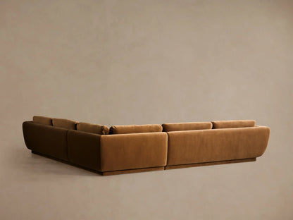 Fontana corner sectional in deep caramel brown velvet, L-shaped, close-up from low angle showing plush cushions & rounded arm.