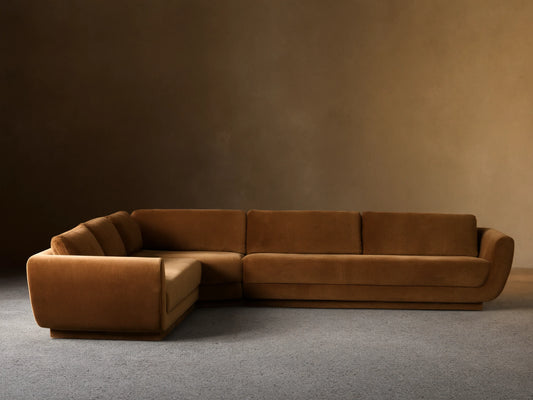 Fontana Corner Sectional, L-shaped, upholstered in warm brown velvet with curved arms, shown on a wooden floor.