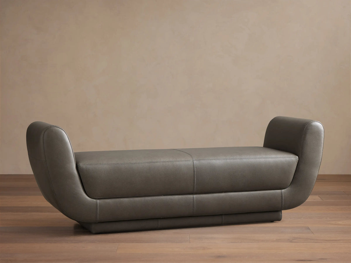 Front view of a dark gray Fontana Leather Bench with curved arms and a sleek, modern design.