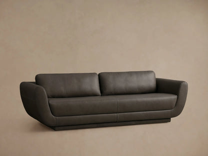 Front view of the charcoal grey Fontana Leather Sofa, with rounded arms, two plump back cushions, and a continuous plinth base.
