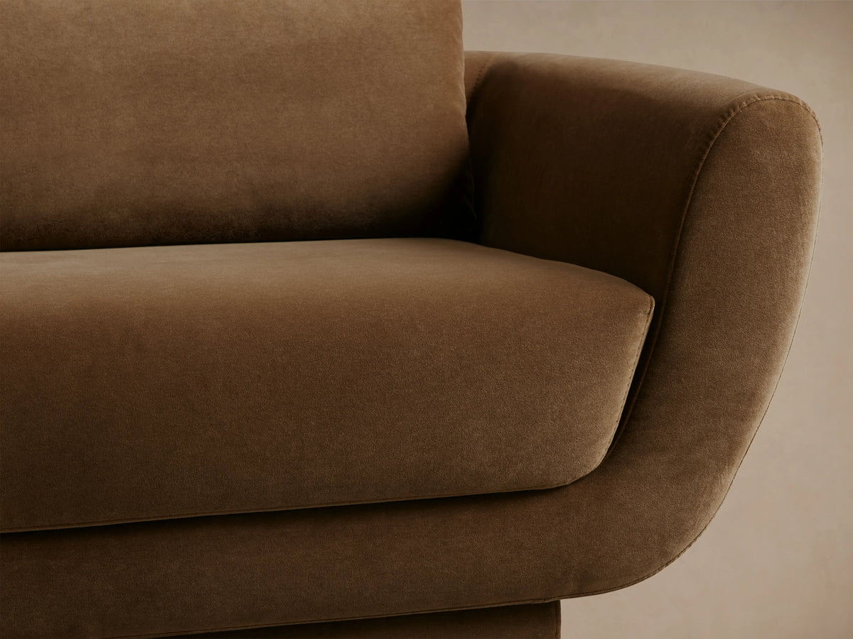 Front view of the brown Fontana Sofa, a two-seater with rounded arms, loose back cushions, and a low, solid base.