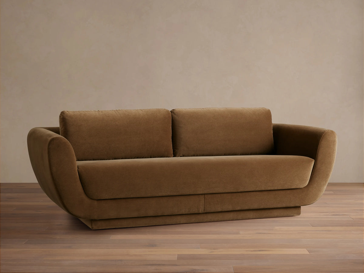 Rear view of the brown Fontana Sofa, showing its sleek, curved backrest and two separate back cushions.