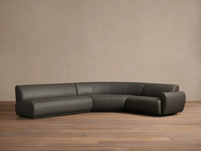 Front view of the Charcoal Gianni Leather Three-Piece Sectional, an L-shaped sofa featuring a curved right section.