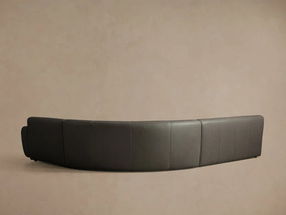 Angled close-up of a dark brown leather Gianni Leather Three-Piece Sectional, showing rounded armrests and visible stitching.