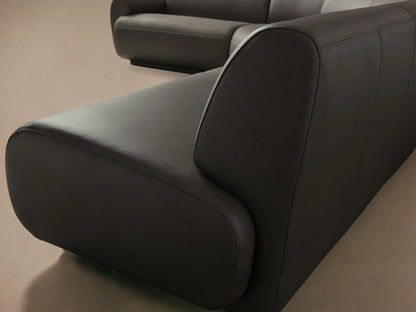 Close-up of the dark brown Gianni Leather Three-Piece Sectional, showcasing the smooth leather and rounded armrest with visible stitching.