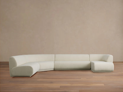 Cream Gianni Armless Four-Piece Chaise Sectional with rounded left corner, two center sections, and right chaise, on wood floor.