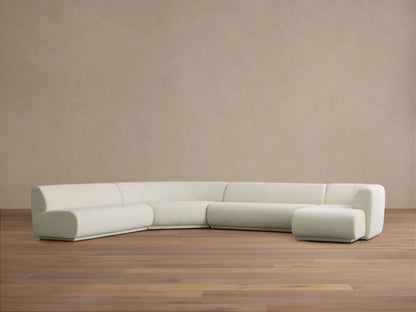 Cream Gianni Armless Four-Piece Chaise Sectional with rounded left corner, two center sections, and right chaise, on wood floor.